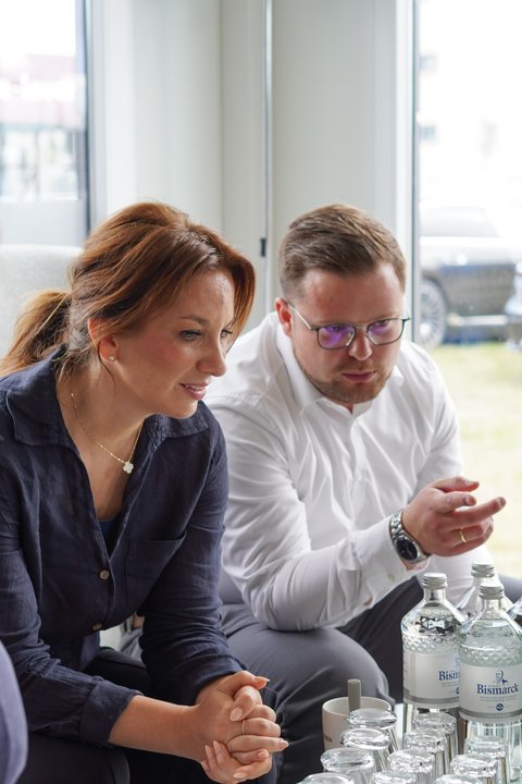 Innenministerin Magdalena Finke informiert sich im Showroom der HP&P Gruppe über das Baugebiet "Auf der Freiheit", neben ihr zeigt Bürgermeister Jonas Kähler auf den Bildschirm eines Laptops