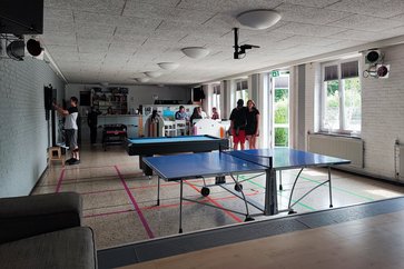Bild zeigt den Saal des Jugendzentrums mit Tischtennisplatten und der Theke