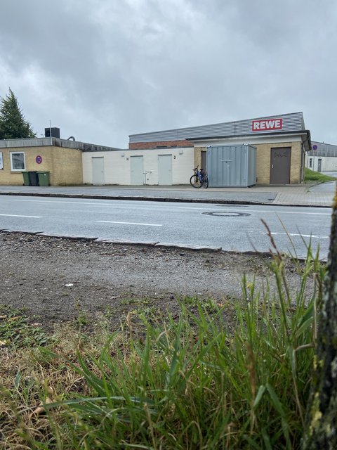 Container, Gebäude, Rewe-Markt und Straße