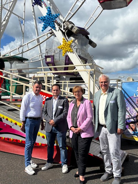 Schausteller Andreas Horlbeck und Milano Jipp sowie Dr. Sabine Sütterlin-Waack und Bürgermeister Stephan Dose vor einem Riesenrad