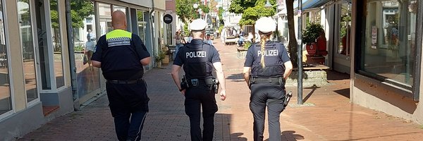 Gemeinsame Kontrolle von drei Personen der Polizei und Kommunaler Ordnungsdienst von hinten mit Blick in die Innenstadt, Stadtweg in Schleswig