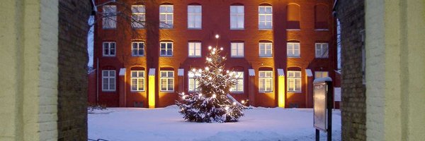 Verschneiter Hof vor dem Stadtmuseum mit einem beleuchteten Weihnachtsbaum
