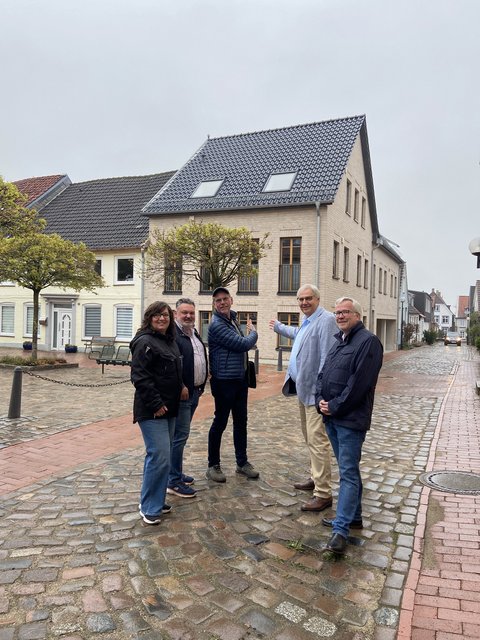 Anja Friedrich (Stadt Schleswig), Dipl. Ingenieur Peter Paustian (HochbauPlanung Paustian), Robert Davids (Gesellschafter Lorenzen Bauunternehmen GmbH) und Stephan Dose sowie Bernward Völmicke (Stadt Schleswig) vor dem Neubau Töpferstr. 14 -