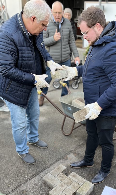 Stephan Dose und Jonas Kähler mit Kelle und Pflastersteinen
