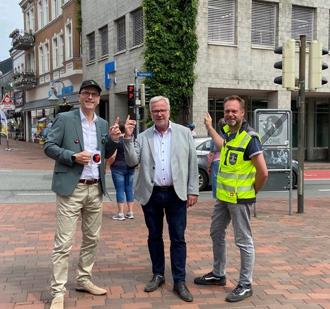 Alwin Dombetzki (Agentur ALDO Studio), Bernward Völmicke (Leiter des Bauamtes) und Torben Krüger (Fachdienstleitung Tiefbau) vor der Wikingerampel am Capitolplatz