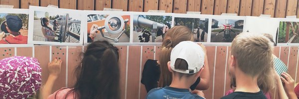 Kinder von hinten an einer Bilderwand