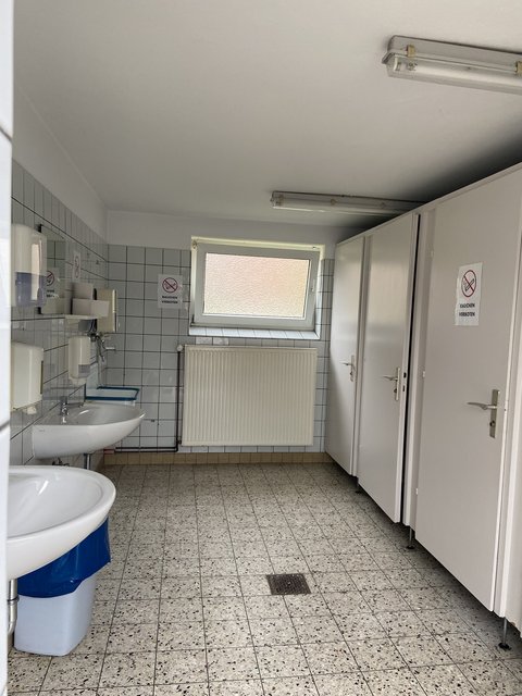 WC-Anlage am Marktbüro, gekachelt mit Waschbecken, Heizung, Fenster und Türen