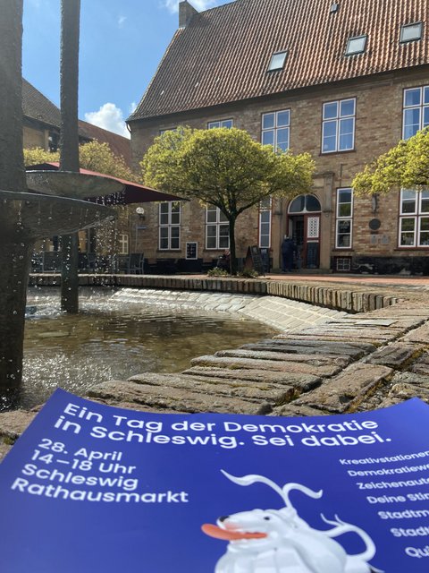 Plakat auf dem Brunnen auf dem Rathausmarkt:Tag der Demokratie auf dem Rathausmarkt: 28. April 2026 ab 14:00 Uhr