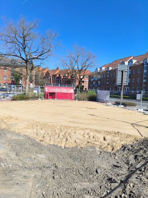 Baustelle mit Füllsand und Blick auf Häuser und Bäume in der Königsstraße