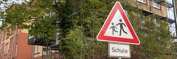 Gerüst am Gebäude der Wilhelminenschule mit einem Verkehrsschild Schule