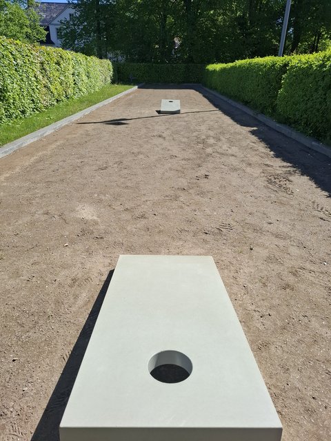 Cornhole-Anlage auf einer Sandfläche im Öffentlichen Grün