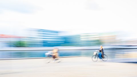 Zwei Personen auf Fahrrädern am Wasser 