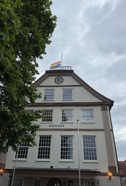 Regenbogenflagge auf Halbmast gehisst auf dem Dach des Rathauses
