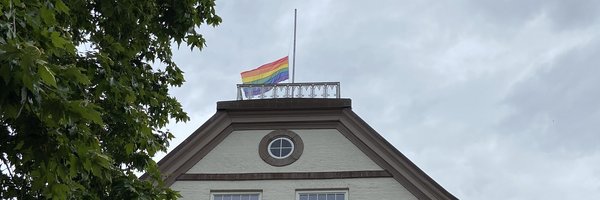 Regenbogenflagge auf Halbmast gehisst auf dem Dach des Rathauses