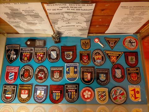 Vitrine im Klassenzimmer zeigt Abzeichen/Aufnäher, u. a. der Stadt Schleswig für deutsch-französisches Bildungsprojekt