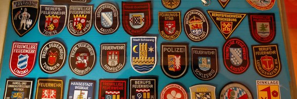 Vitrine im Klassenzimmer zeigt Abzeichen/Aufnäher, u. a. der Stadt Schleswig für deutsch-französisches Bildungsprojekt
