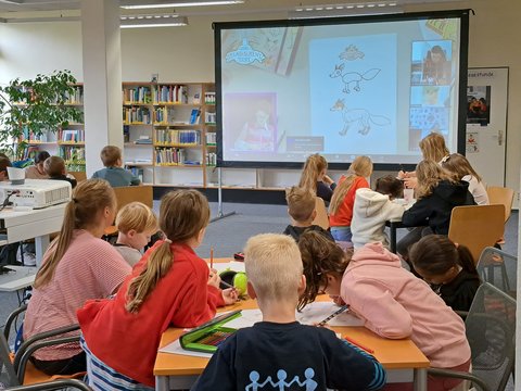 Bild zeigt Kinder von hinten bei der Zeichenstunde: „Die Schule der magischen Tiere“ in der Stadtbücherei