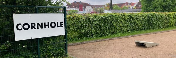 Schild Cornhole vor einer öffentlichen Grünanlage
