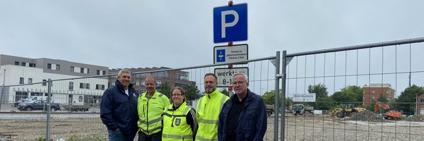 Helge Schütze (Stadtmarketing), Ove Jürgens (Firma Greve), Yvonne Lingner und Torben Krüger (FD Tiefbau) und Bernward Völmicke (Fachbereichsleiter Bau) an einem Parkschild und vor einem Bauzaun am ZOB