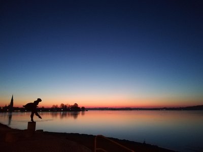 Skulptur "Schleswigerin" bei Nacht mit der Schlei im Hintergrund