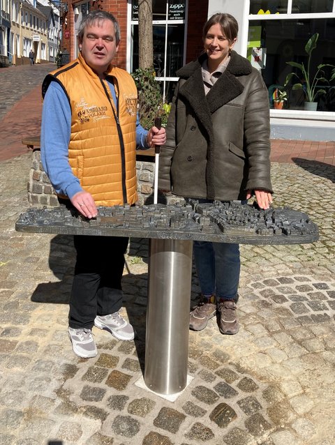 Carsten Lasarsch (Inklusives Schleswig) und Josephine Schäfer (Stadtplanung Stadt Schleswig) vor dem neuen bronzenen Stadtmodell am Kornmarkt