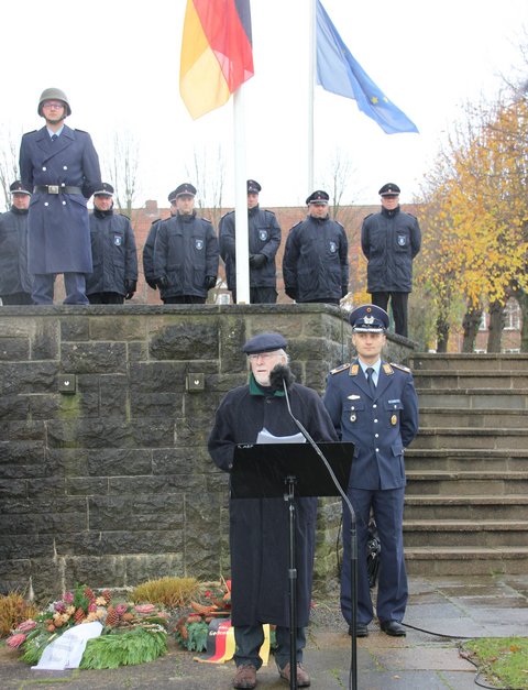 Bild zeigt Hans-Peter Scheibel (AG Volkstrauertag) anlässlich des Volkstrauertages am 19.11.23 am städtischen Ehrenmal am Rosengarten in Schleswig