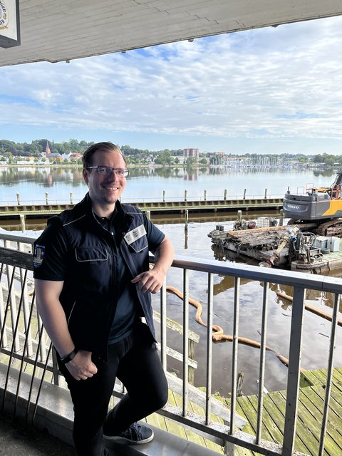 Ordnungsamtleiter vor dem ehemaligen Liegeplatz der Simone mit dem Containerschiff im Hintergrund.