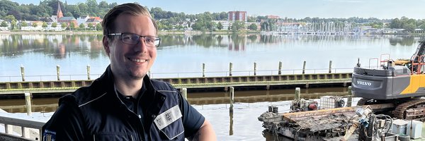 Ordnungsamtleiter vor dem ehemaligen Liegeplatz der Simone mit dem Containerschiff im Hintergrund.