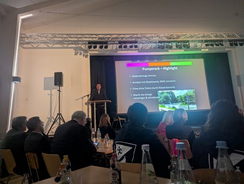 Christian Sievers, Leiter des Jugendzentrums steht vor einer Präsentation und erhält einen Preis