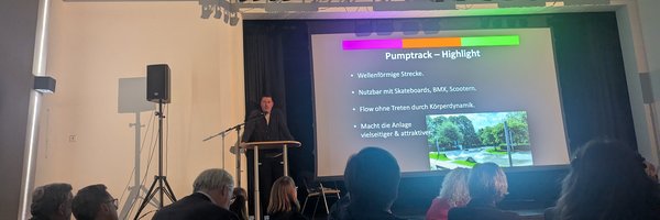 Christian Sievers, Leiter des Jugendzentrums steht vor einer Präsentation und erhält einen Preis