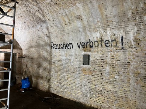 Historischer Eiskeller von innen mit Baugerüst und Schrift Rauchen verboten