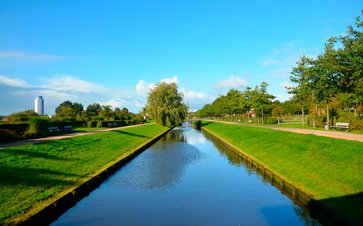 Bild zeigt eine Landschaft die durch einen Fluss getrennt ist und im Hintergrund ist der Wikingerturm zu sehen