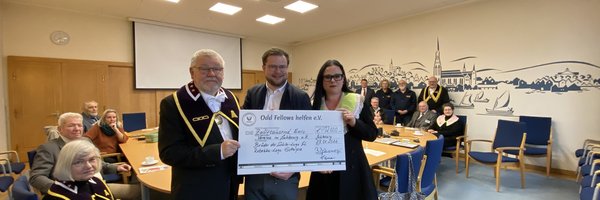 Spendenübergabe der Odd Fellows Logen im Rathaus Schleswig. 3 Personen halten einen übergroßen Scheck in der Hand