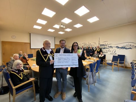 Spendenübergabe der Odd Fellows Logen im Rathaus Schleswig. 3 Personen halten einen übergroßen Scheck in der Hand
