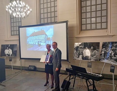 Kulturstaatssekretär Guido Wendt überreicht Dr. Dörte Beier, Leiterin des Stadtmuseums Schleswig, die Auszeichnung im Jüdischen Museum in Rendsburg