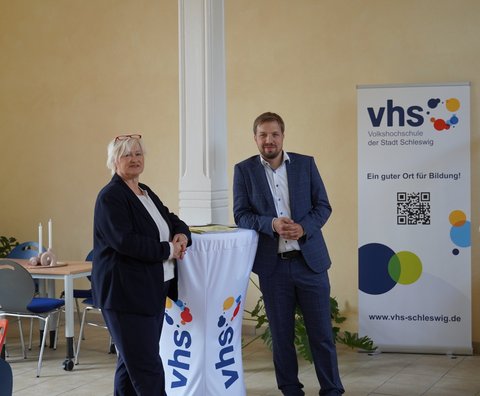 Dr. Julia Pfannkuch (Fachbereichsleitung Bildung, Kultur und Ordnung) und Florentin Viebig (Leiter vhs Schleswig) in der Eingangshalle der Volkshochschule