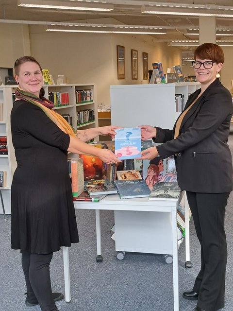 Tahmani Carstensen und Christina Weinbrandt Übergabe eines symbolischen Schecks in der Stadtbücherei
