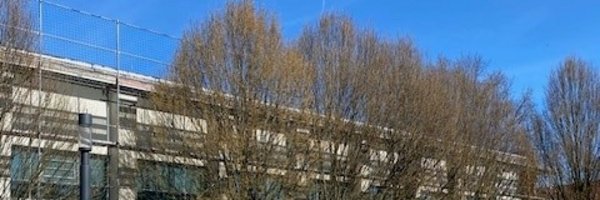 Eingezäuntes Gebäude mit einer Skulptur als Wahrzeichen für die Bruno-Lorenzen-Schule