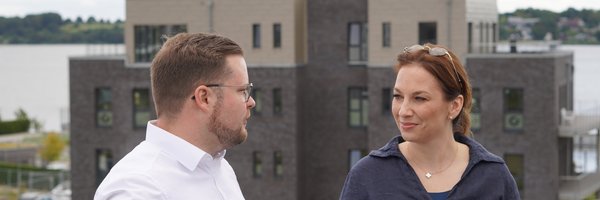 Innenministerin Magdalena Finke und Bürgermeister Jonas Kähler auf einer Dachterrasse im Baugebiet "Auf der Freiheit" mit Blick auf umliegende Gebäude und die Schlei