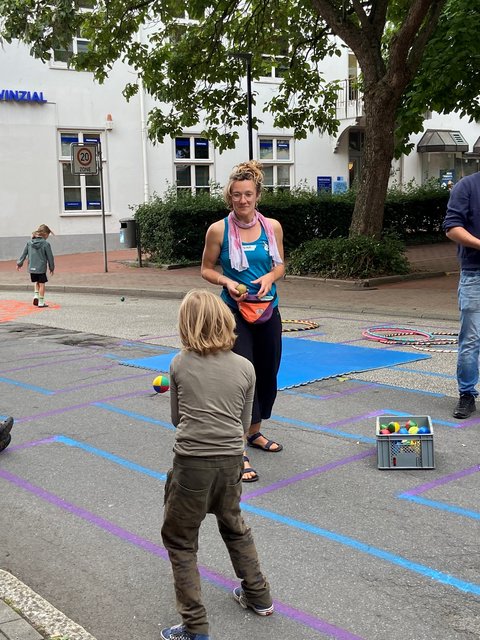 Spielende Personen auf der bemalten Straße - Schwarzer Weg.