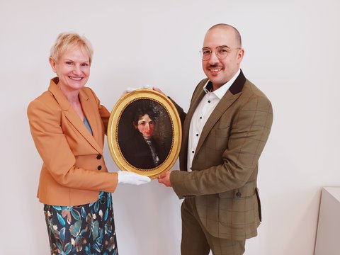 Das Schleswiger Stadtmuseum wird seit Jahrzehnten von der Fielmann Group AG unterstützt. Diesmal brachte der Leiter der Schleswiger Fielmann-Niederlassung, Jonas Gropp, ein  Porträtgemälde von der Hand des Malers Conrad Christian August  Böhndel aus dem Jahr 1812 als Geschenk mit. 