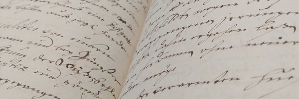 Bild zeigt ein aufgeschlagenes, handschriftlich beschriebenes Buch des Kreis- und Stadtarchivs