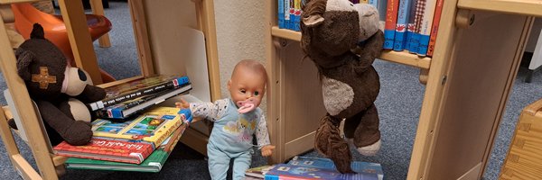 Kuscheltiere zwischen Büchern in der Stadtbücherei