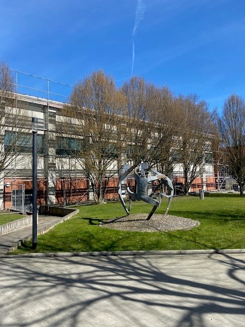 Eingezäuntes Gebäude mit einer Skulptur als Wahrzeichen für die Bruno-Lorenzen-Schule