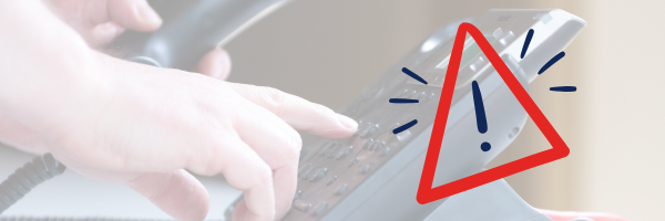 Hand mit Telefonhörer und Tastenfeld, darüber ein Warndreieck